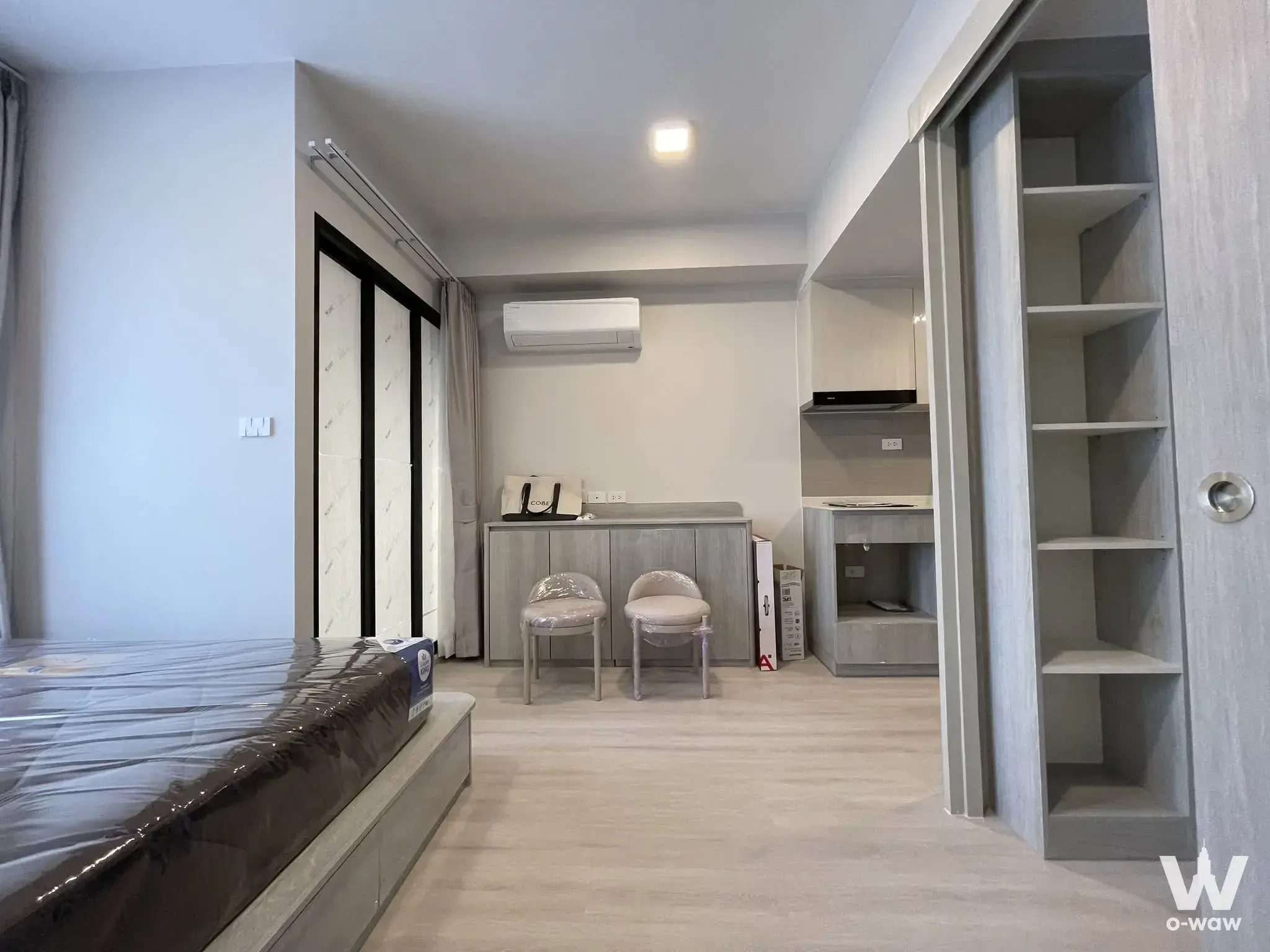 New 1-bed condo bedroom in COBE Ratchada-Rama 9 with a grey platform bed and wood-look wardrobe