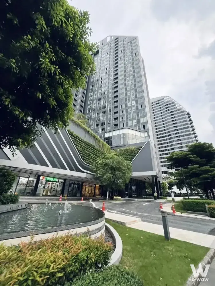 Exterior view of Ideo Mobi Sukhumvit Eastgate high-rise with courtyard fountain and greenery
