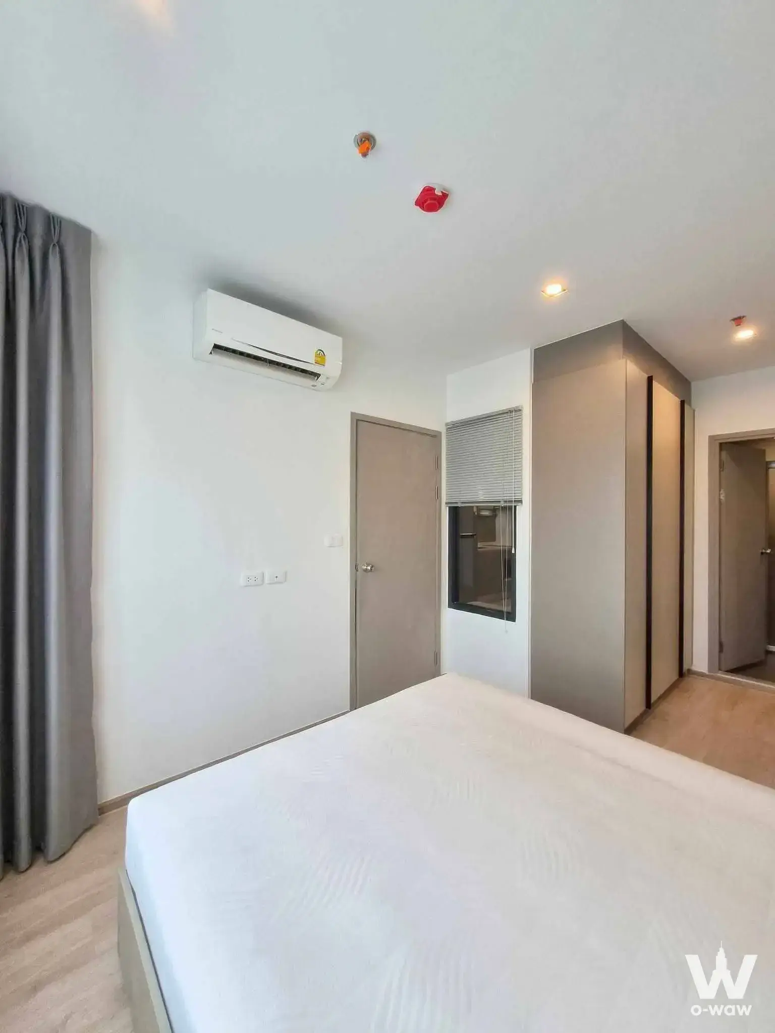 Unfurnished bedroom in a 1-bed condo for rent at IDEO Rama 9 featuring a queen bed and large built-in wardrobe