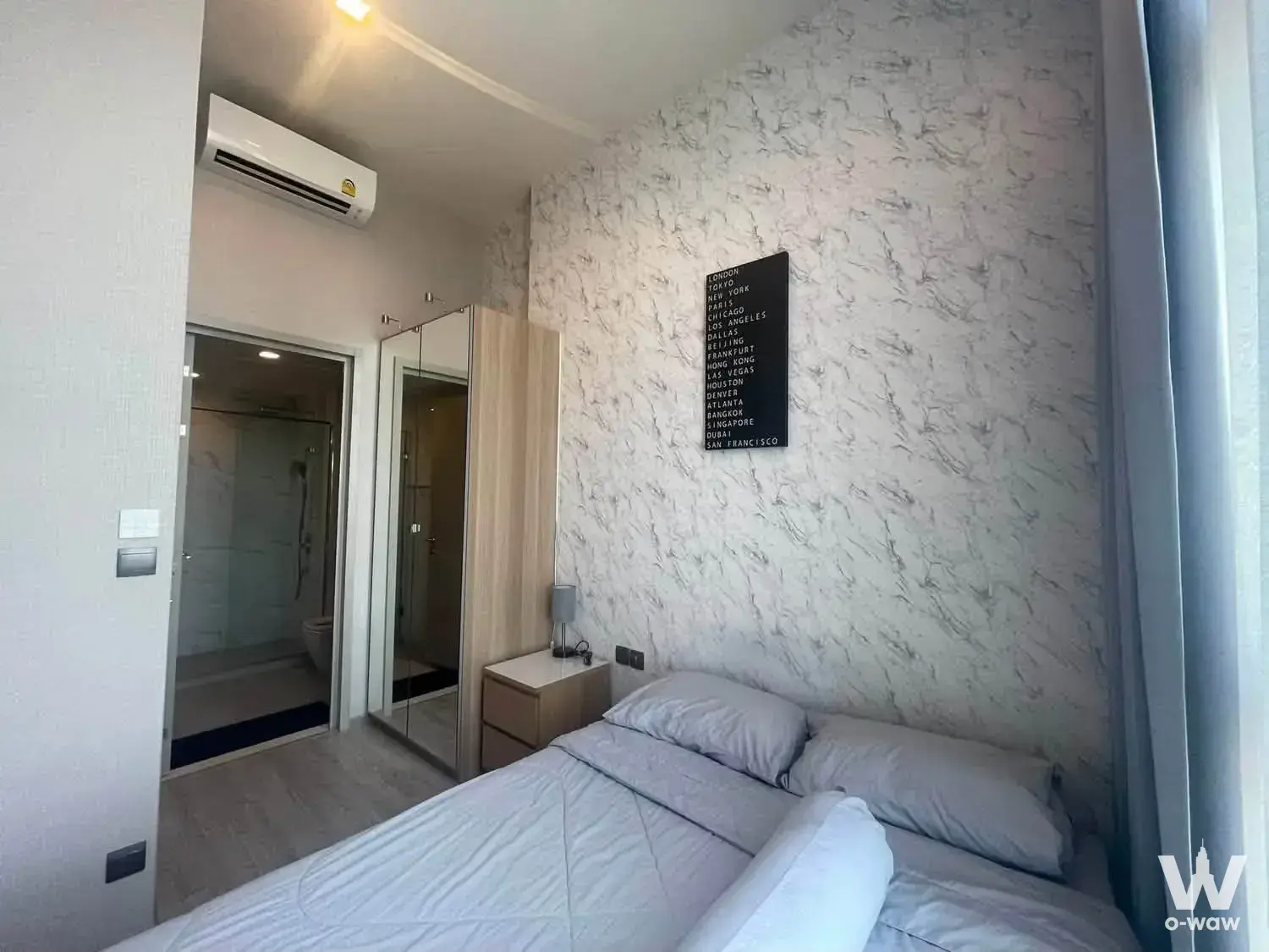 Queen bed with marble accent wall and mirrored wardrobe in a 1-bed condo for rent at THE LINE Sukhumvit 71