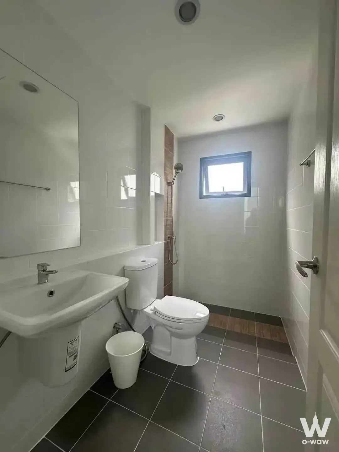 Modern bathroom in Grande Pleno Sukhumvit-Bangna townhouse with white tiles and frameless mirror