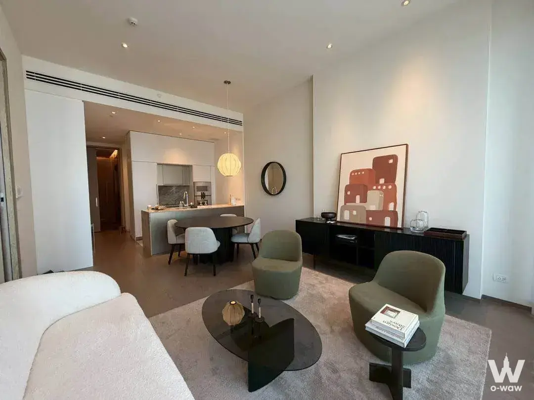 Living room in SCOPE Langsuan with boucle sofa, sage chairs, and open kitchen