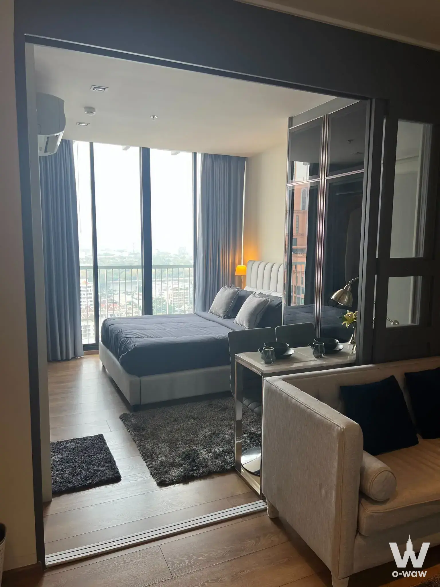 Bedroom suite in a Park Origin Phrom Phong condo featuring a queen bed and balcony access with an open-plan lounge