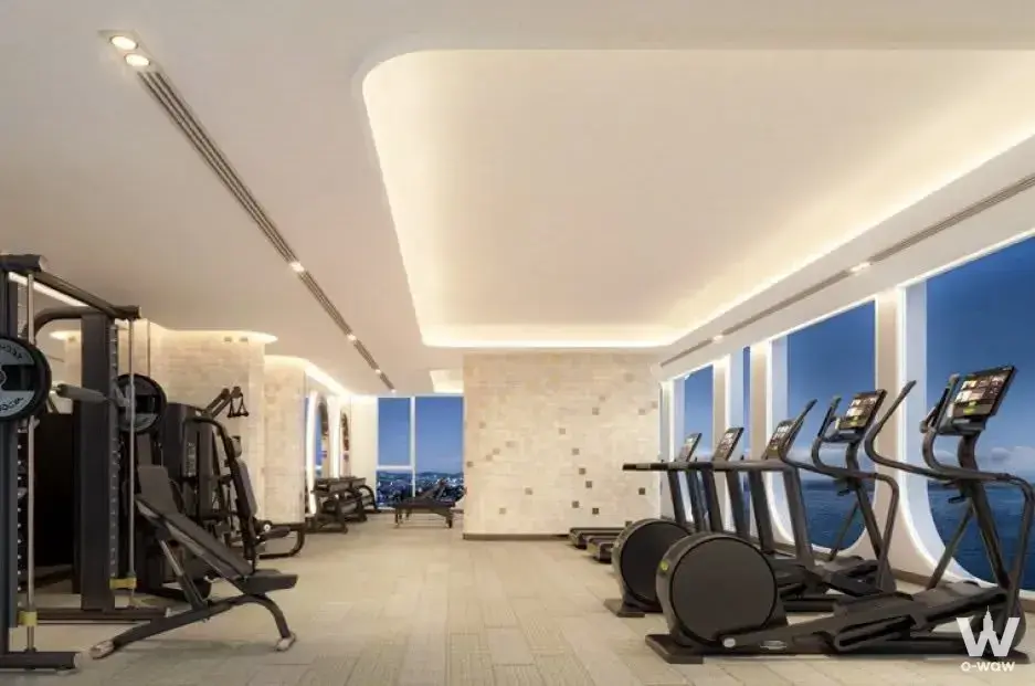 PTY Residence Sai 1 gym featuring treadmills, cable crossover machine, and floor-to-ceiling windows with ocean horizon view