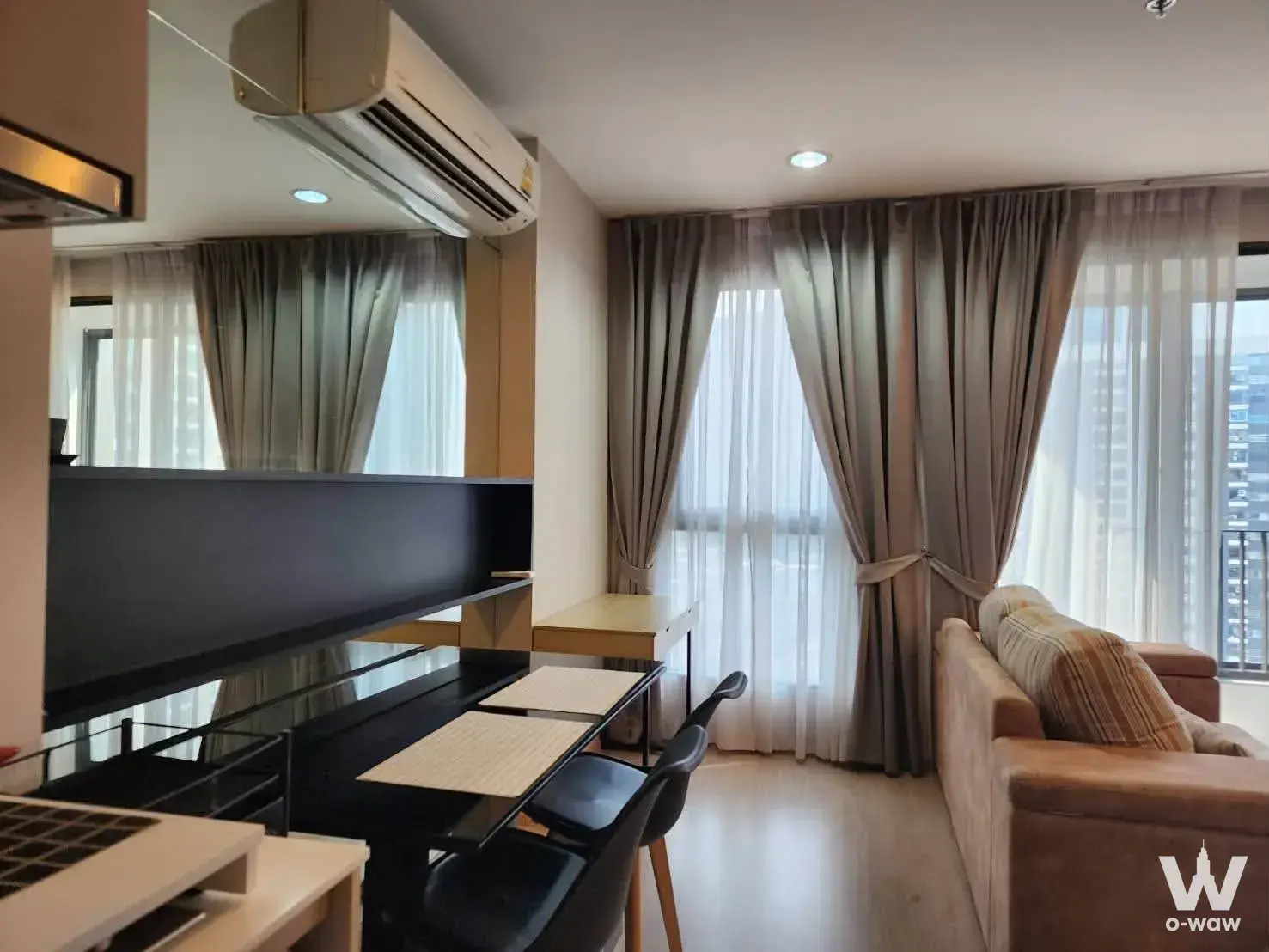 Living room in Ideo Q Ratchathewi with fabric sofa and floor-to-ceiling windows offering city views