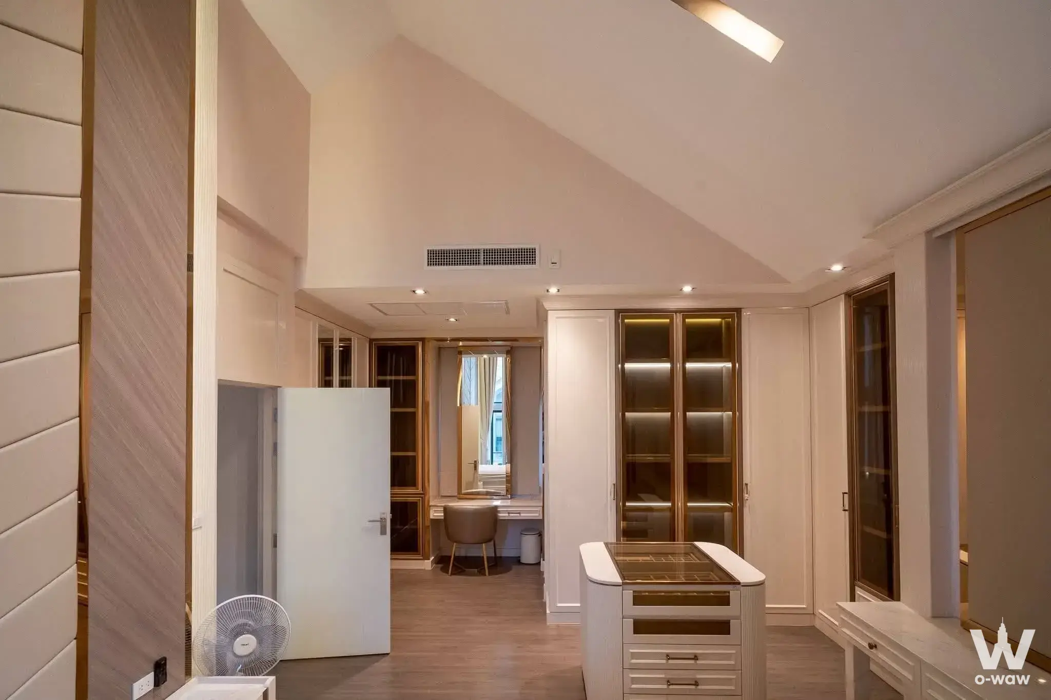 Luxury walk-in closet with glossy white wardrobes, gold accents, and central island in 3-bed house for rent at Rama 9