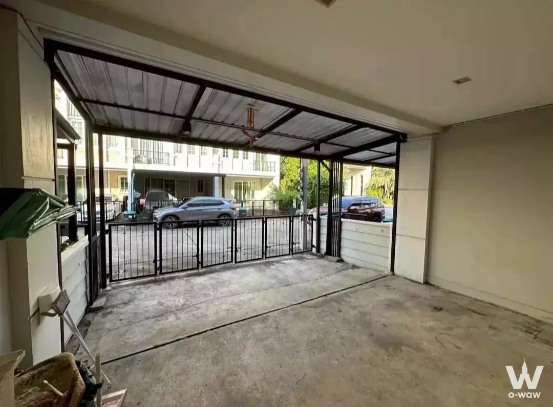 Golden Town 3 Bangna townhouse carport with concrete floor, metal roof, sliding gate, and street view