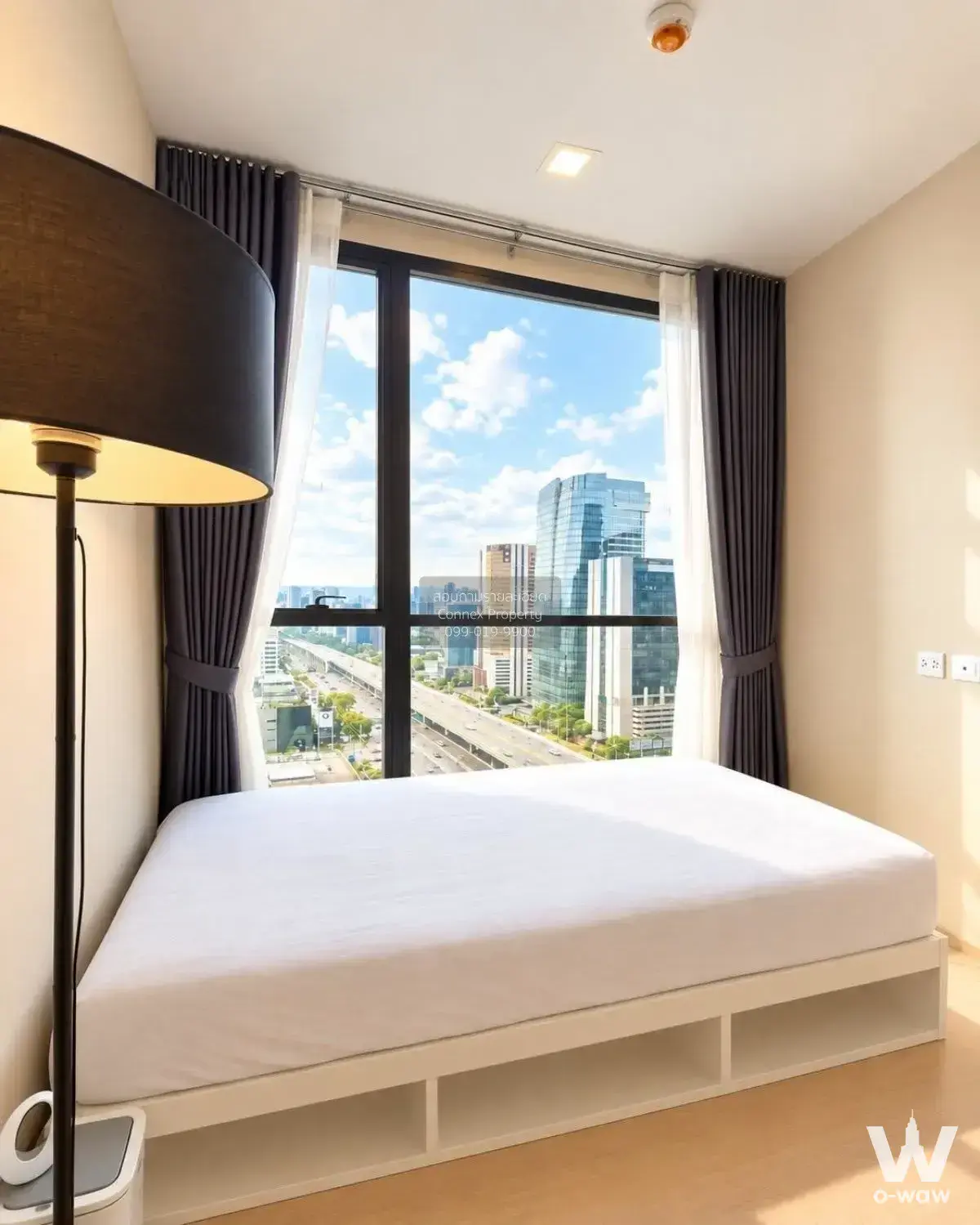 Modern bedroom in a 2-bed The Privacy Jatujak rental with a platform bed and floor-to-ceiling city-view window