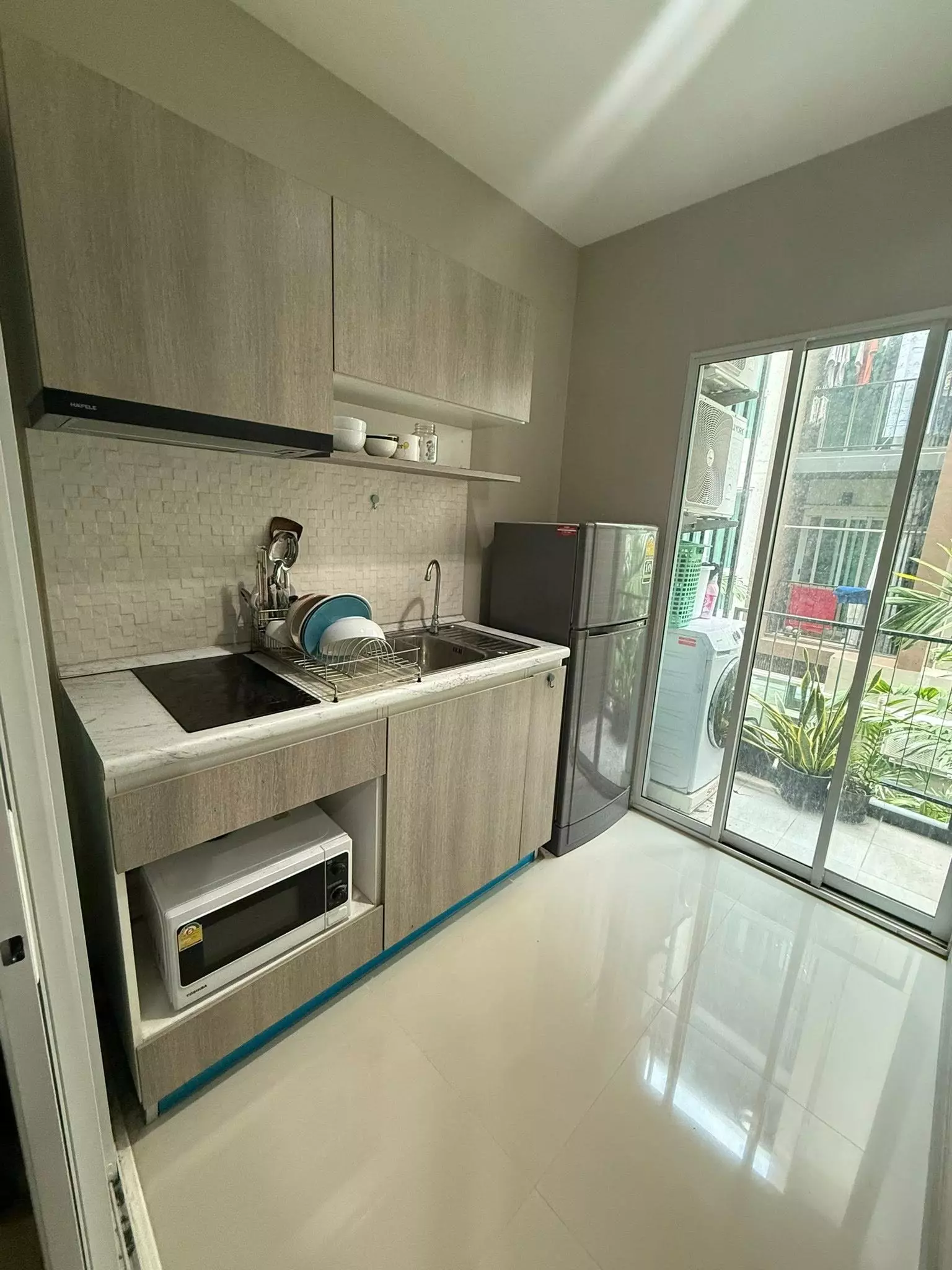 Compact kitchenette with balcony access at One Plus Mahidol 6 condo