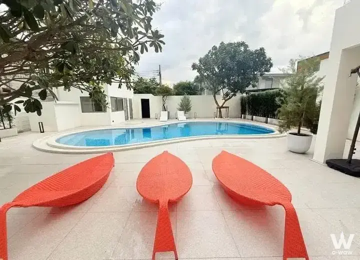 Kidney-shaped pool with orange chairs in private backyard at La Maison 24