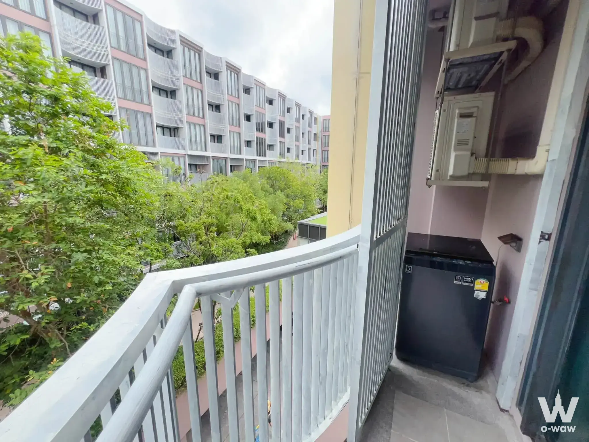 Narrow service balcony with washing machine and AC unit in a Kawa Haus condo