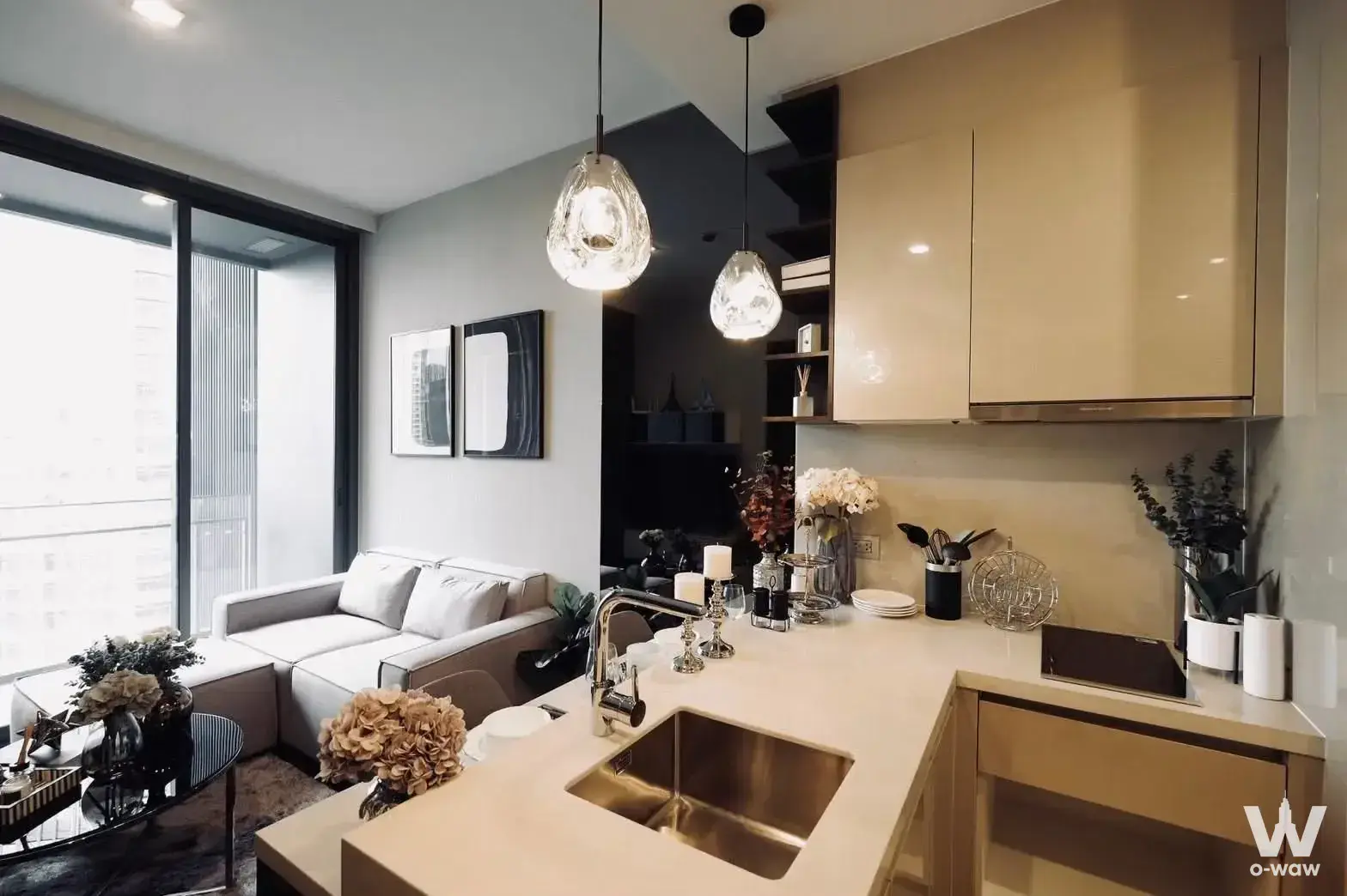 Living area with sectional sofa and quartz island overlooking city views in LAVIQ Sukhumvit 57