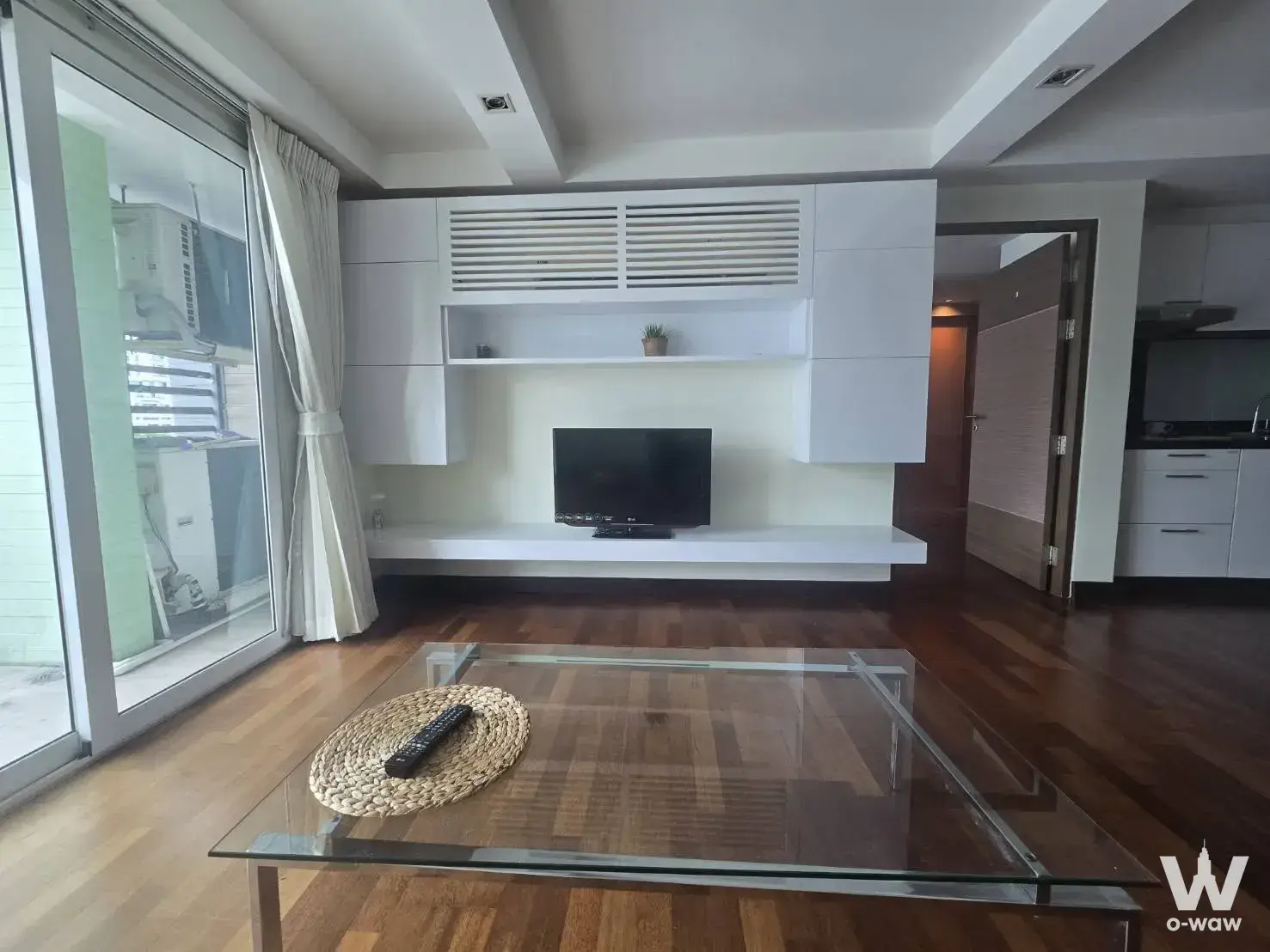 Bright living room in a 1-bed condo for rent at DLV Thong Lo 20 with white cabinetry and floor-to-ceiling glass doors
