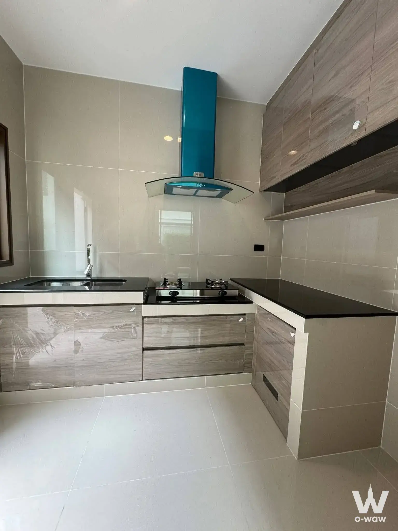 Narinsiri Rama 9 kitchen with grey cabinets, black countertops, and distinctive teal range hood