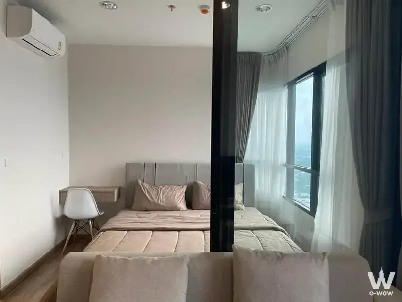 Minimalist bedroom in Niche MONO Sukhumvit Bearing condo for sale with grey bed and city view