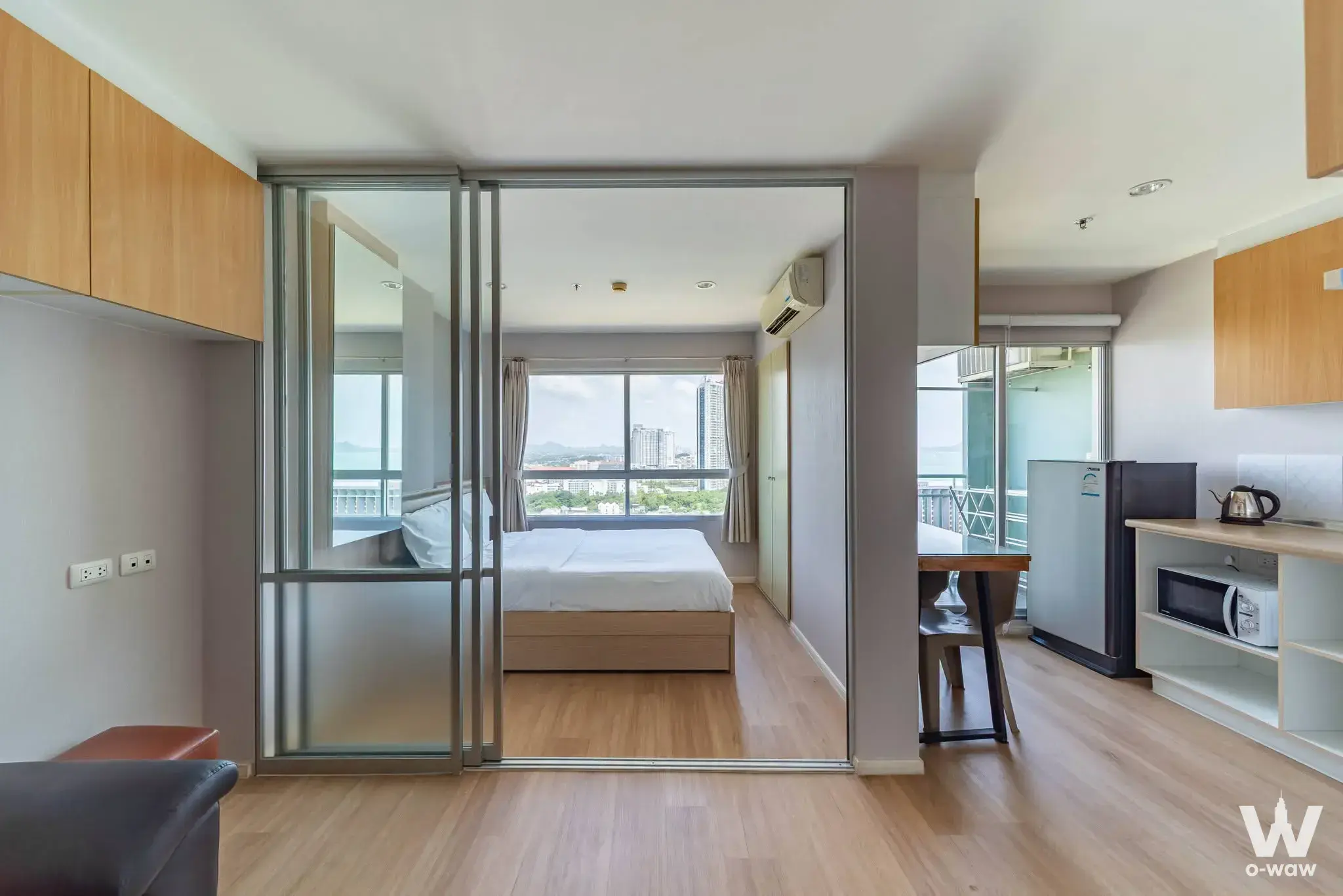 Open-plan studio in Lumpini Park Beach Jomtien featuring a glass partition and compact kitchenette