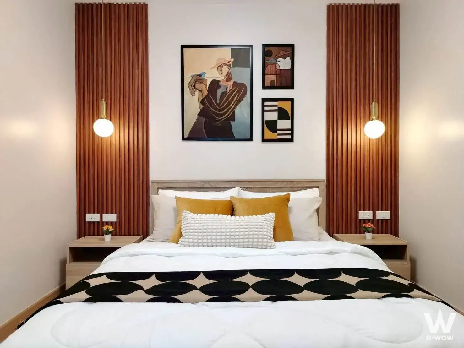Staged bedroom in a City Home Tha Phra condo with wood slat paneling and mustard accents