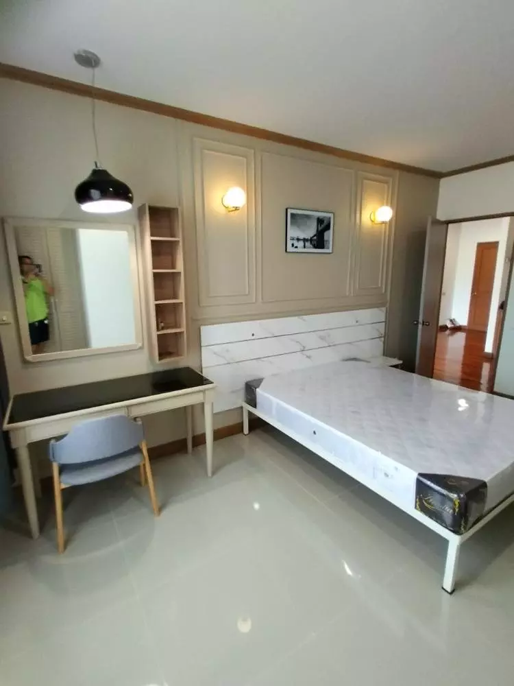 Minimalist bedroom in Baan Chaopraya condo with faux marble headboard and wood desk