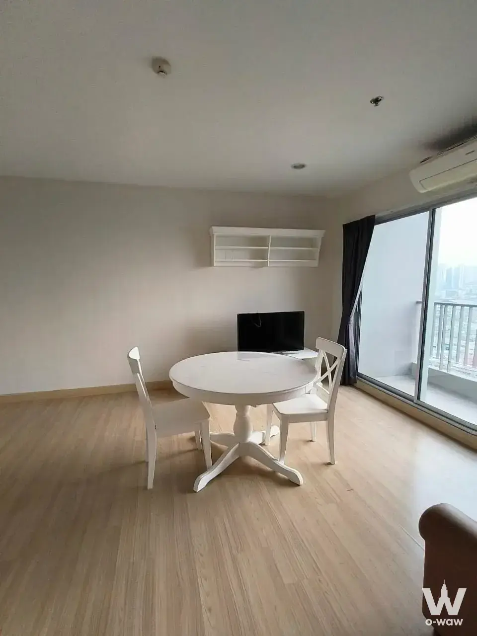 Living room with white dining set and balcony access in Motif Sukhumvit Bangna rental house