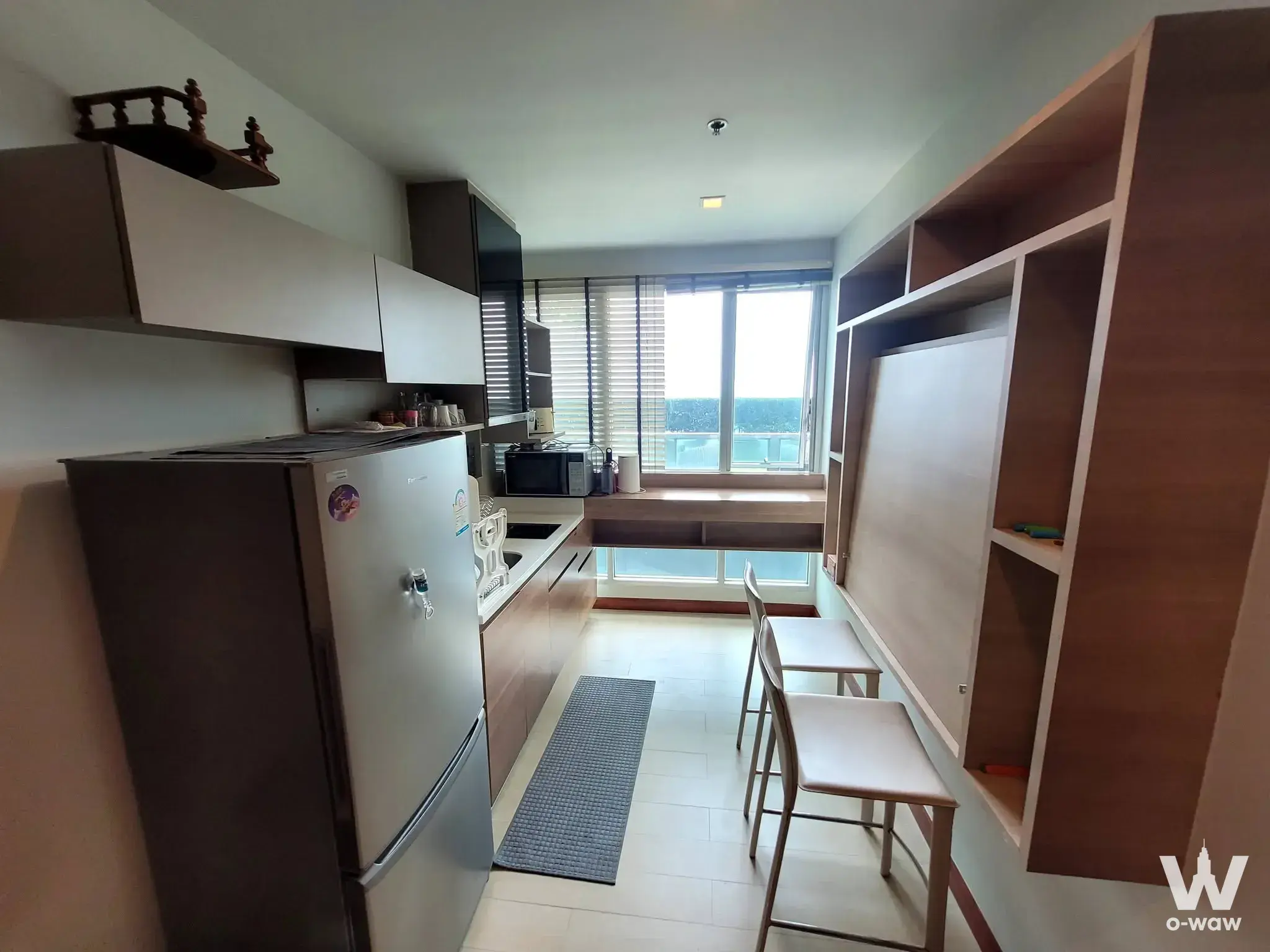Compact 1-bed condo kitchen in RHYTHM Phahon-Ari with stainless steel fridge and fold-down desk