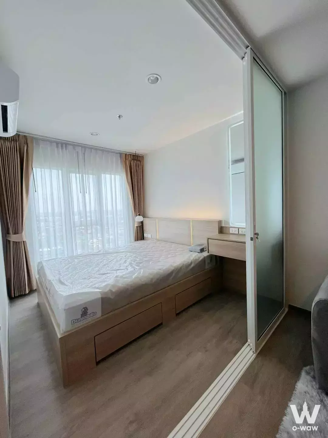 Minimalist bedroom with oak bed frame and LED headboard in Regent Home Bangna 1-bed rental unit
