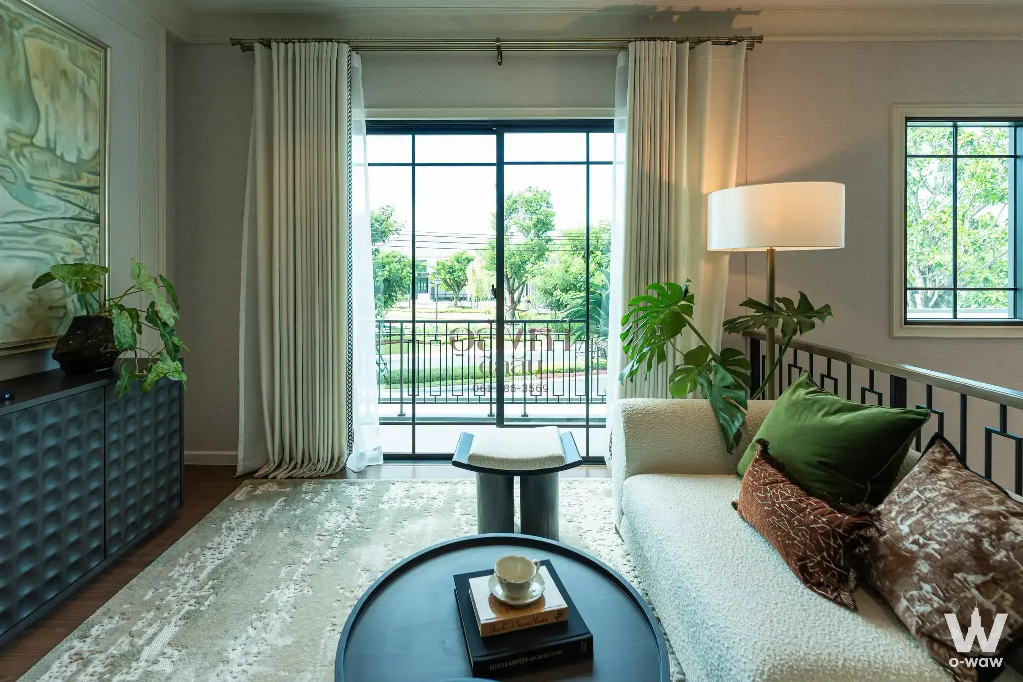 Cream boucle sofa and green velvet accents in a furnished living room with balcony access in this 5-bed Setthasiri