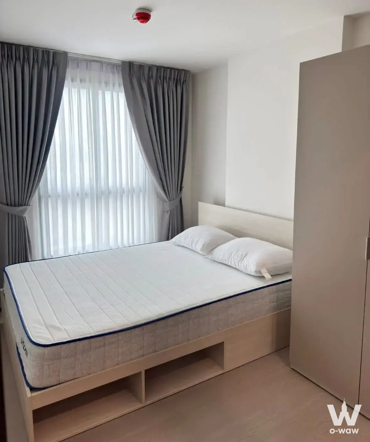 Bedroom in Good Day Sukhumvit 93 condo with wood bed frame and beige wardrobe