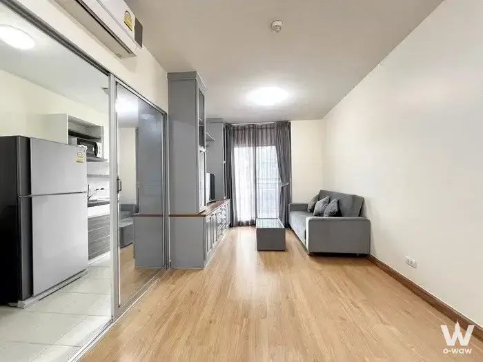 2-bed condo for rent in Supalai Veranda Ratchawipha-Pracha Chuen showing a grey sofa, mirrored kitchen doors, and modern