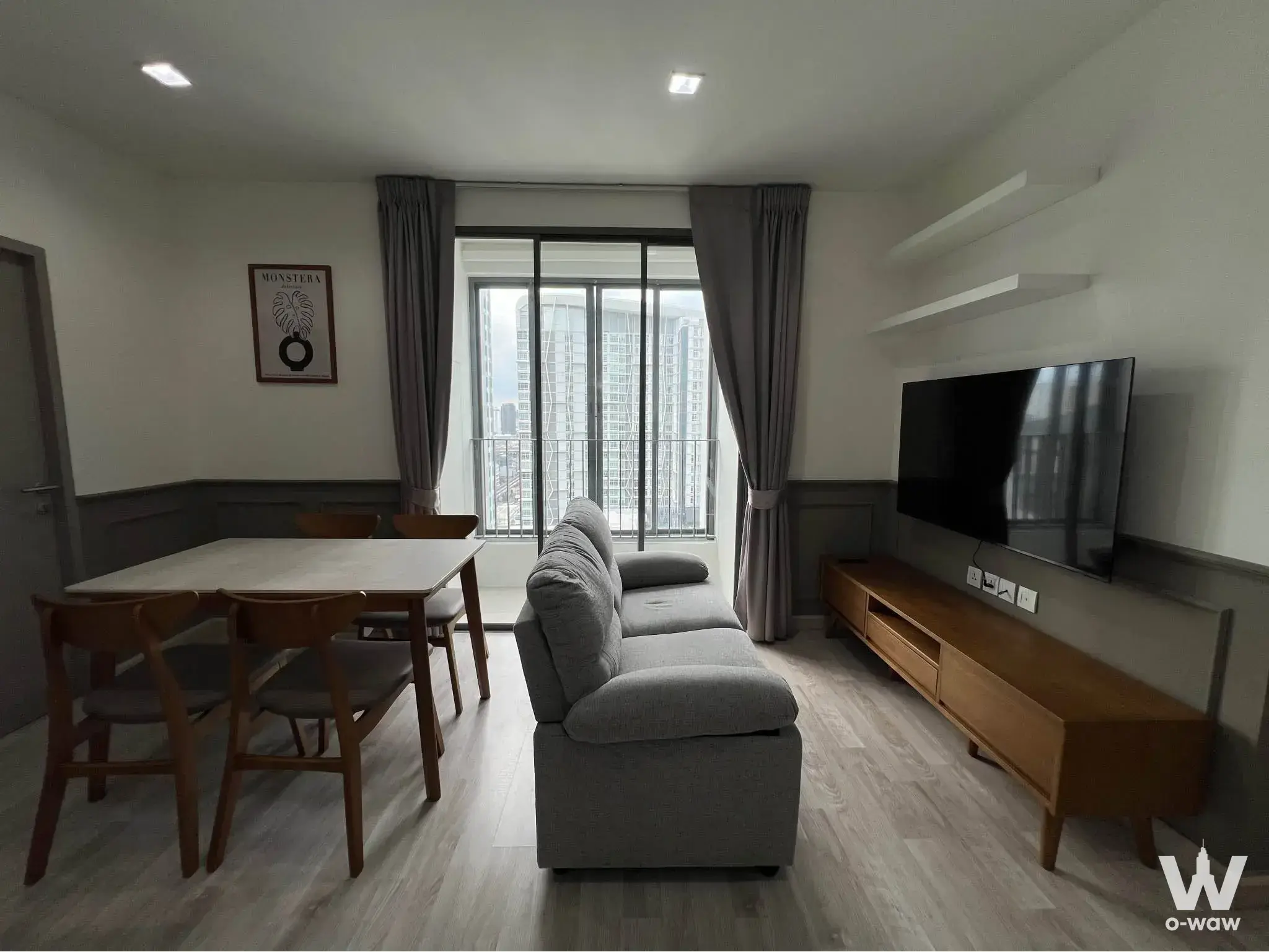 Spacious living space in an Ideo Mobi Sukhumvit 81 unit with city views through large sliding glass doors