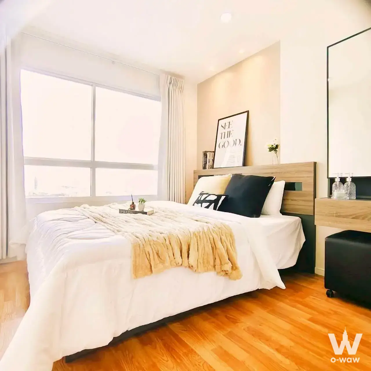 Modern bedroom in Lumpini Park Phetkasem 98 condo with mustard throw, wooden headboard, and city view from large window