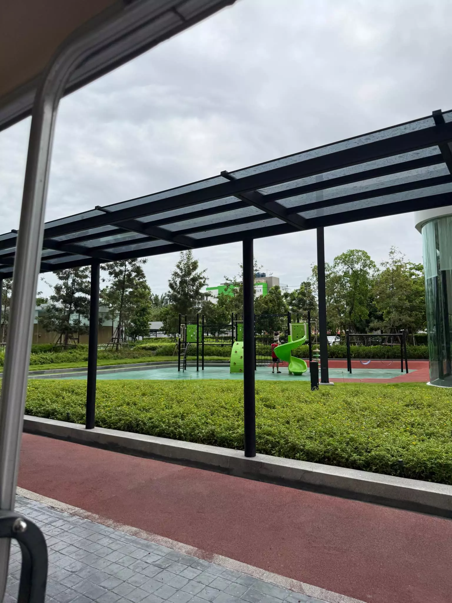 Outdoor playground with green climbing structures and jogging track at Skyrise Avenue Sukhumvit 64