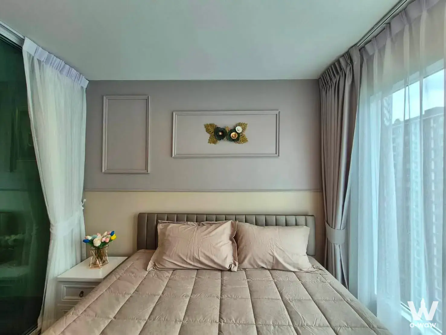 Bright bedroom with tufted headboard, two-tone walls, and floor-to-ceiling windows in Regent Home Bangna
