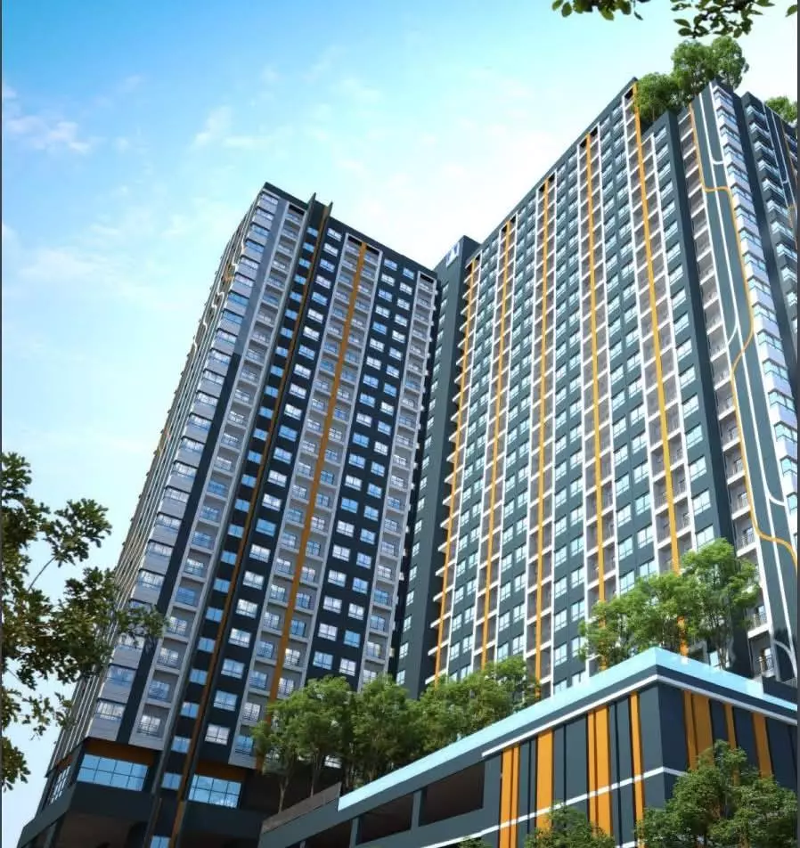 Exterior view of Lumpini Ville Pattanakarn towers with charcoal facades, mustard accents, and lush ground landscaping