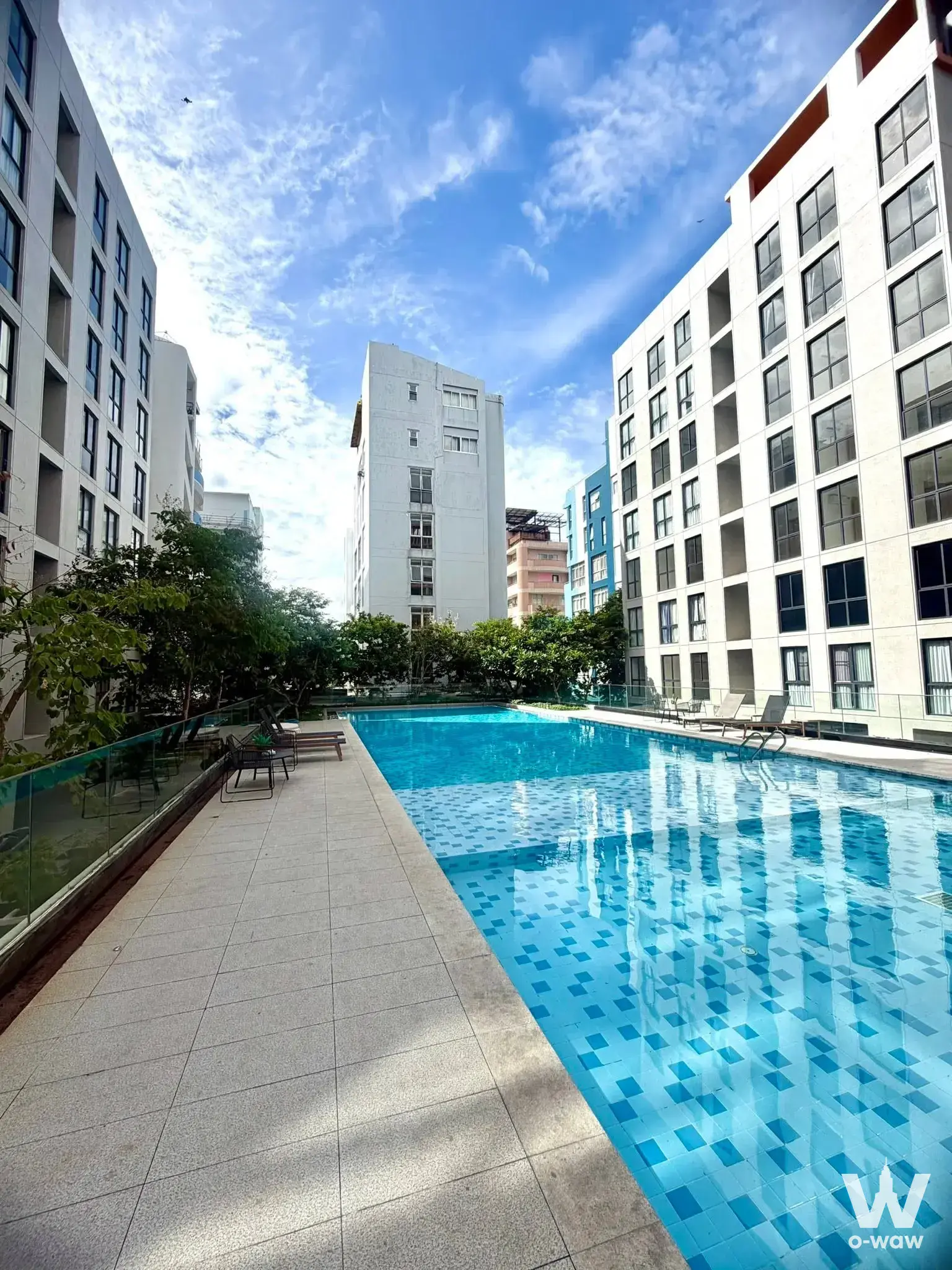 Cyan-tiled swimming pool with lounge chairs at Regal Srinakarin 40