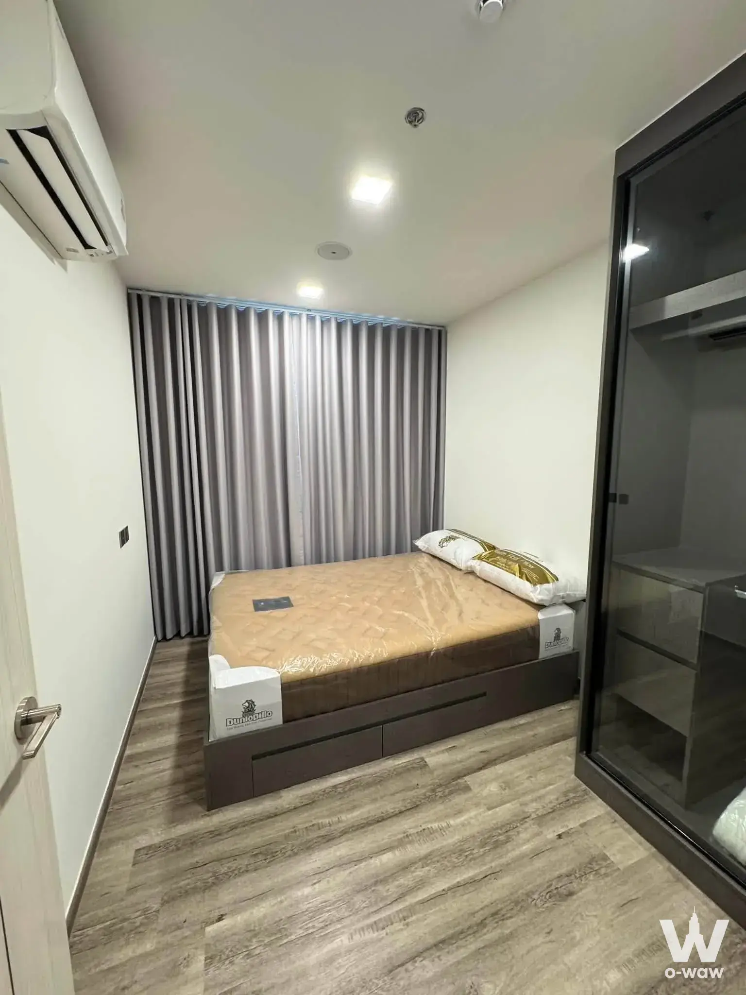 Bedroom in Modiz Vault Kaset Sripatum with wrapped mattress and smoked glass wardrobe
