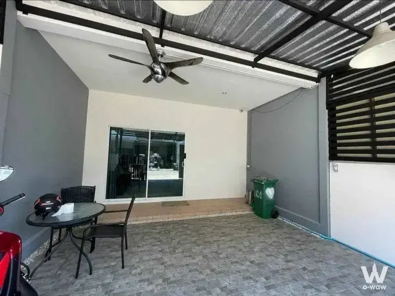 Semi-outdoor patio with wicker chairs and ceiling fan, part of a 3-bed townhouse for rent in Villette City Pattanakarn