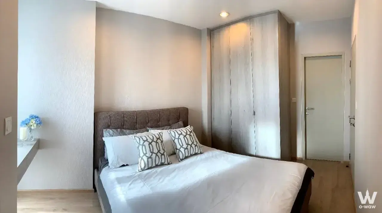 Minimalist bedroom with tufted headboard bed and floor-to-ceiling wardrobe in Ideo Q Ratchathewi