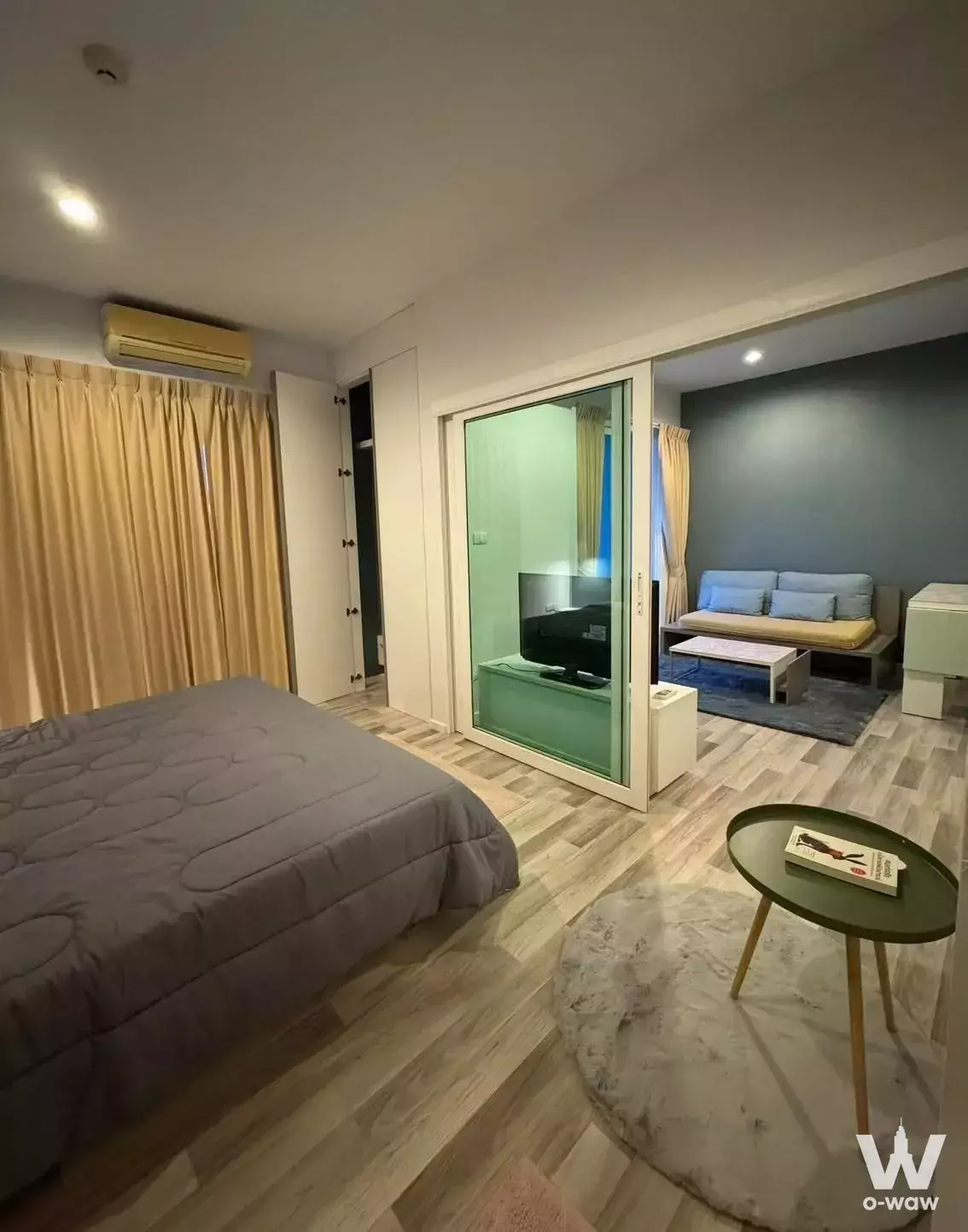 Open-plan 1-bed condo in North 5 featuring blue sofa and translucent green room divider