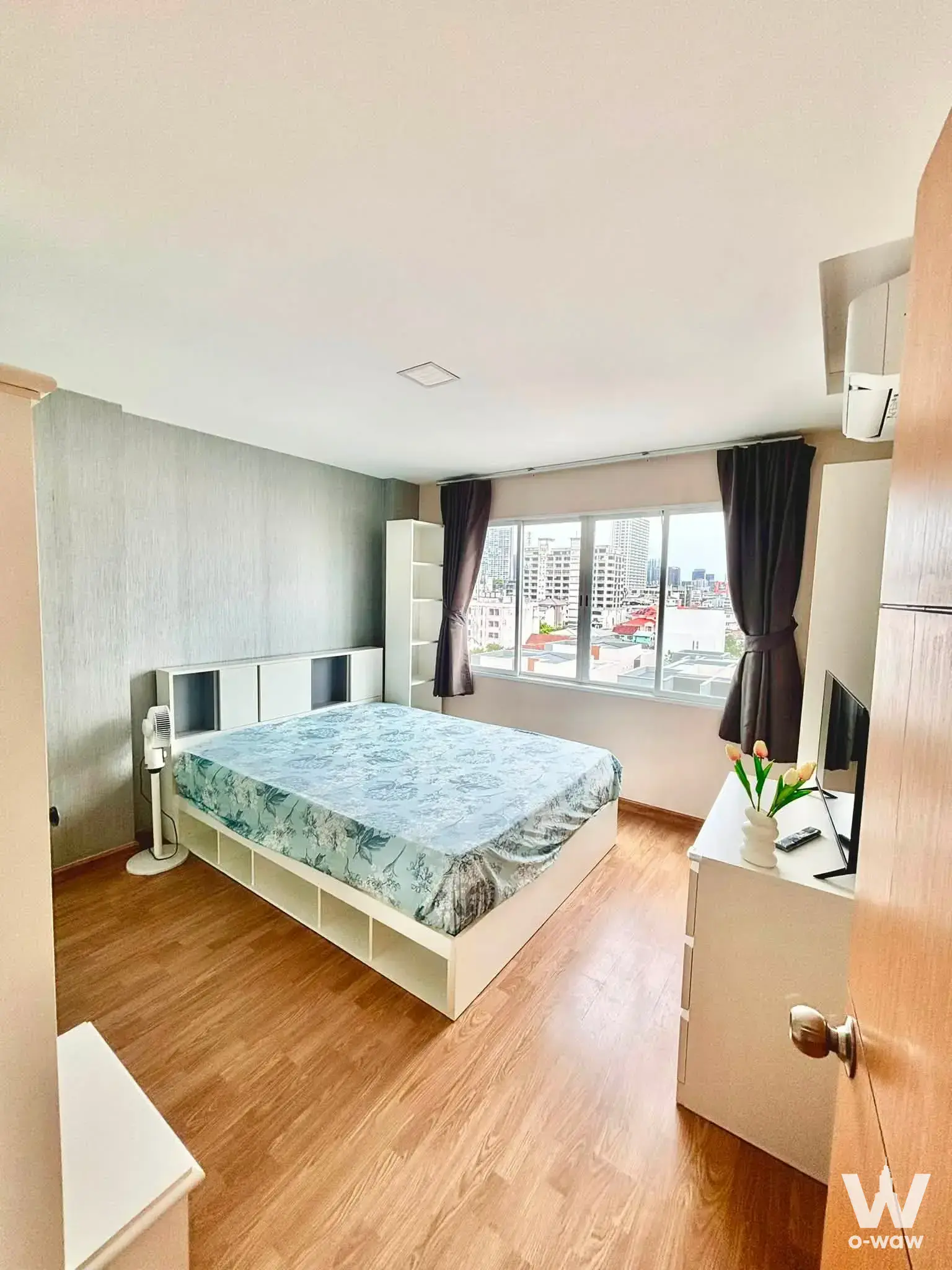 Furnished bedroom in a M Ladprao condo with city view, built-in storage, and grey accent wall