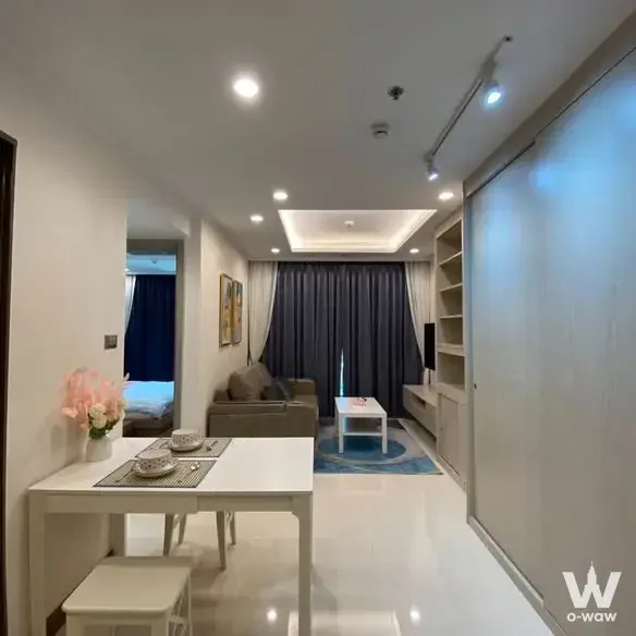 Open-plan studio at Supalai Oriental Sukhumvit 39 with white dining set and grey sofa