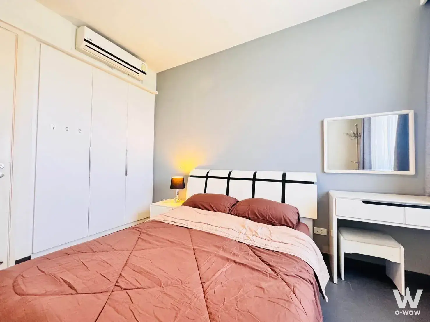 Furnished bedroom with rose duvet and white sliding wardrobe in Unixx South Pattaya condo