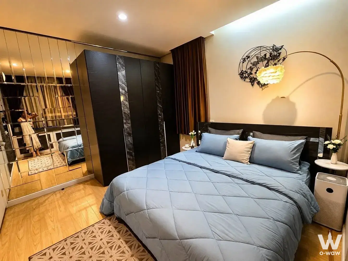 King bed with brass lamp and mirrored wardrobe in this 1-bed rental at TC Green Rama 9