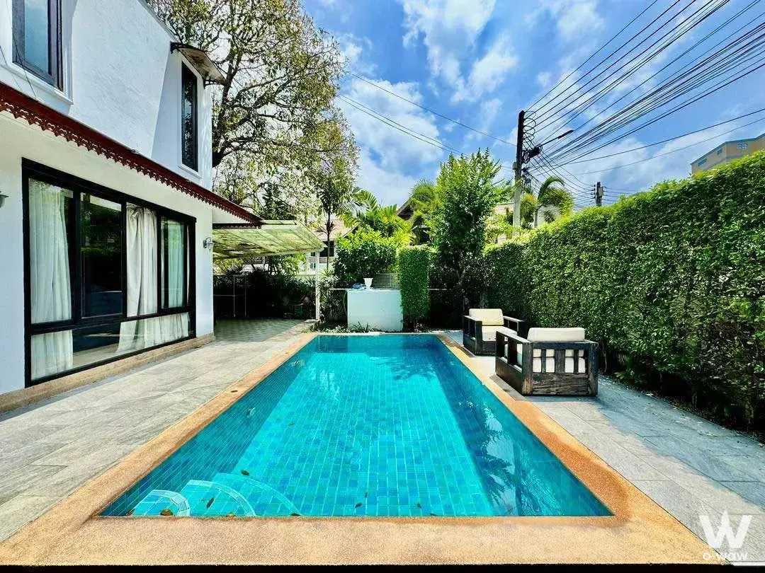 Private pool villa backyard with blue mosaic lap pool and grey stone deck at Palm Lakeside Villas