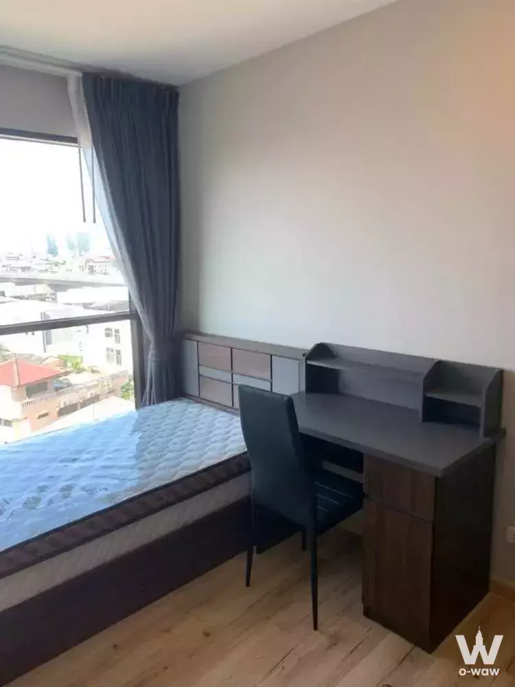 Modern bedroom in Brix Condominium Charan 64 with built-in desk, storage, and large window