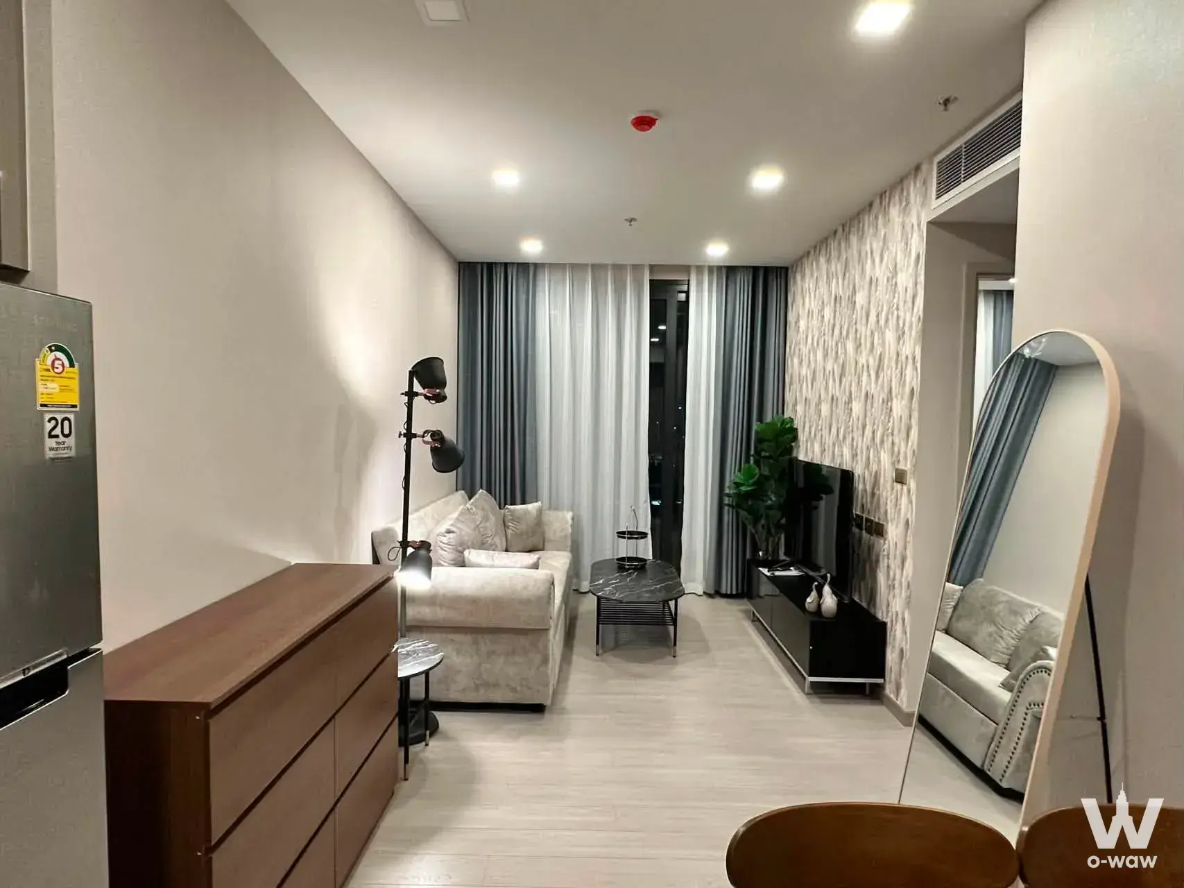 Furnished living room in a 2-bed Asoke condo with grey sofa and night city view