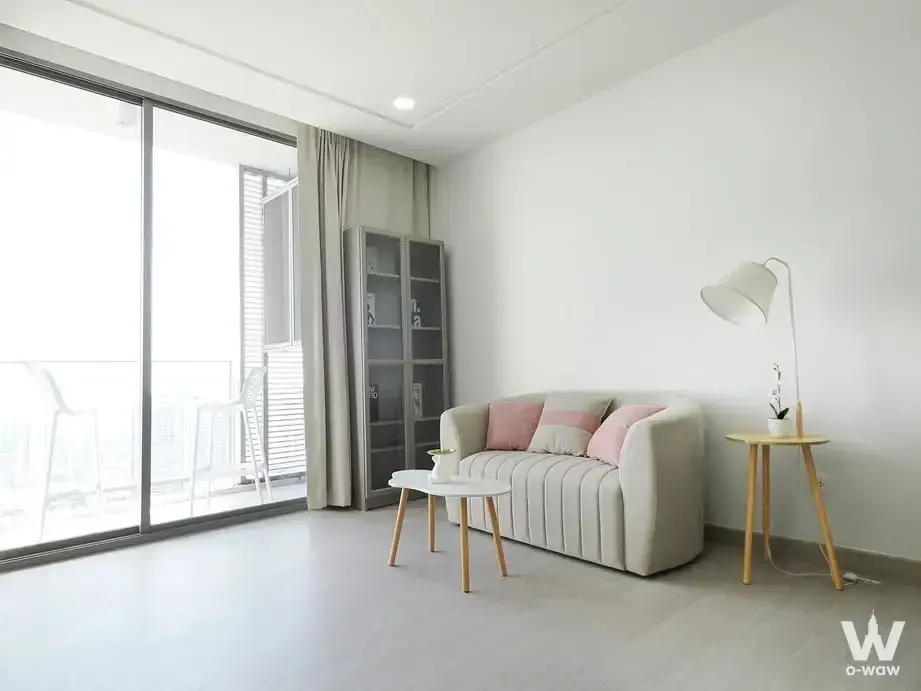 Minimalist living room with beige sofa, glass cabinet, and balcony access in 333 Riverside condo