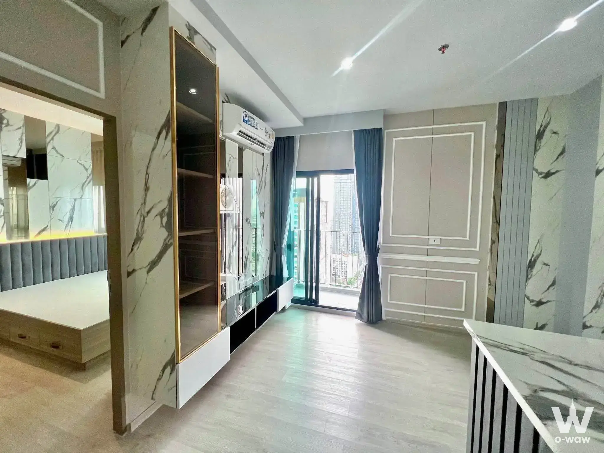 Modern 1-bed condo living room in Altitude Unicorn-Tha Phra with marble entertainment center and city view