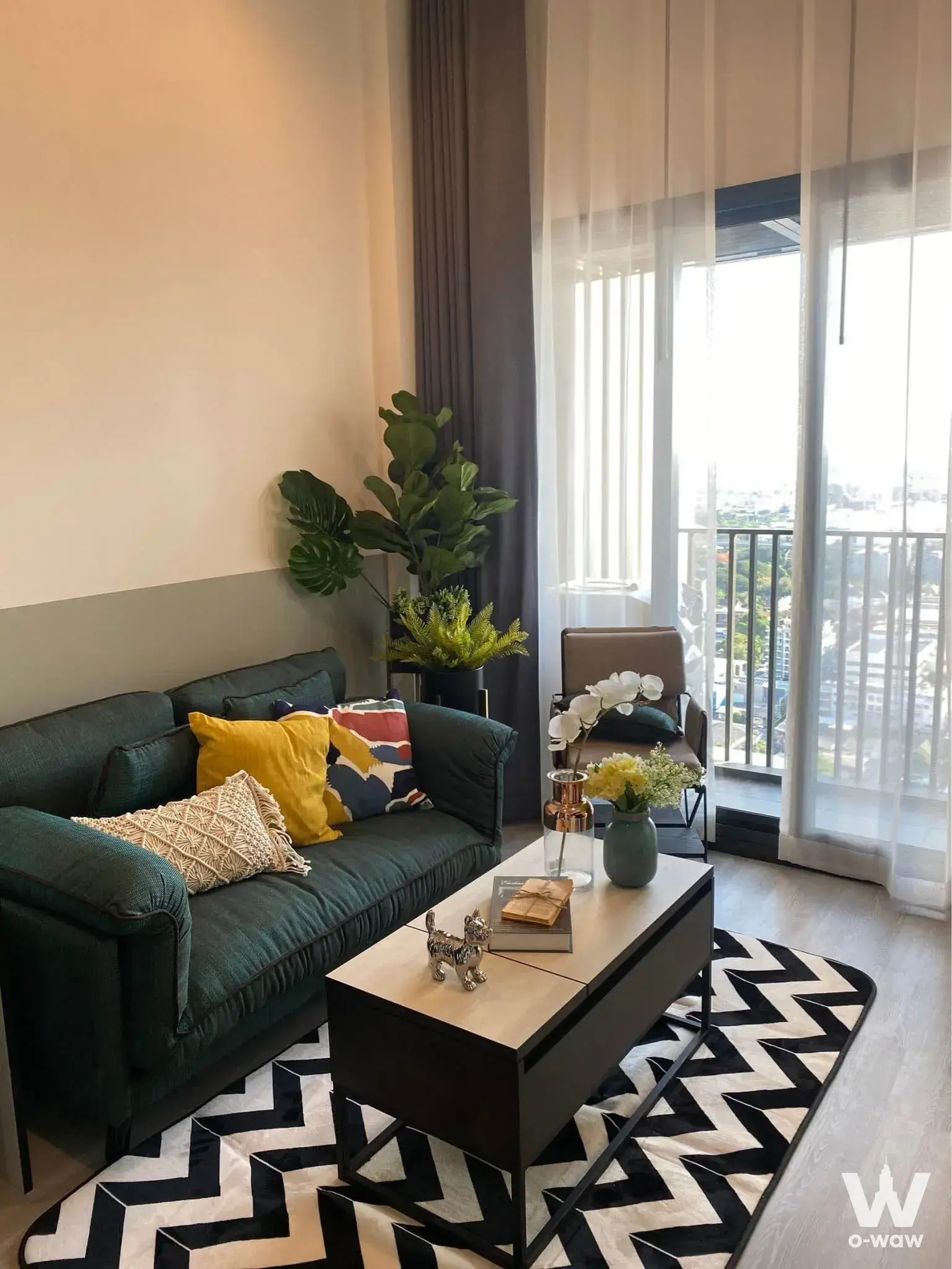 Living room in THE LINE Sukhumvit 71 featuring a green sofa and large balcony city view