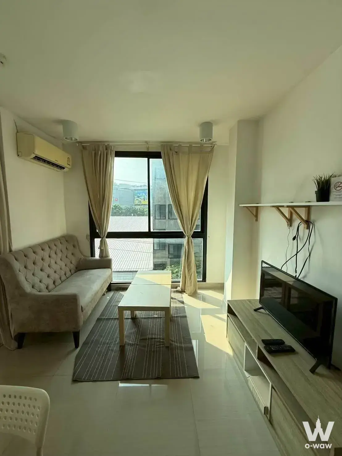 Living room with beige sofa and city view in Chateau in Town Ratchada 17