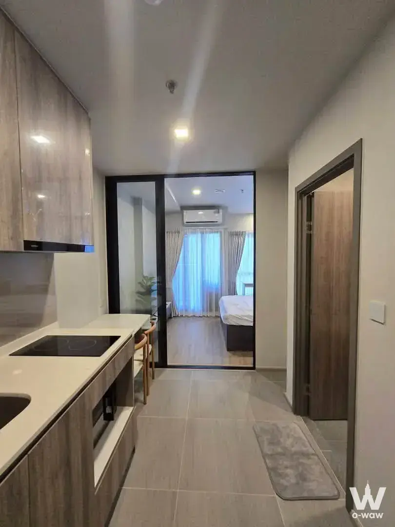 Open-plan studio with kitchenette and bedroom view in M Ladprao condo